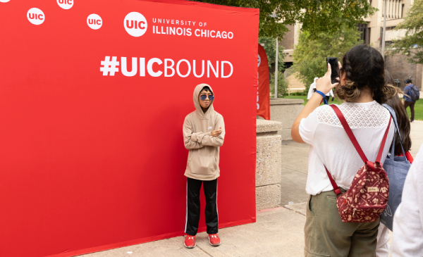 Student taking photo against #uicbound background